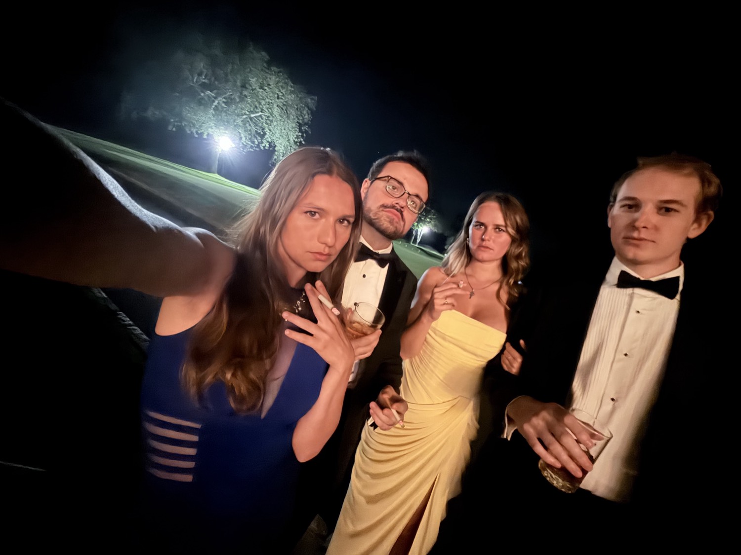 Four guests on the polo field at night.